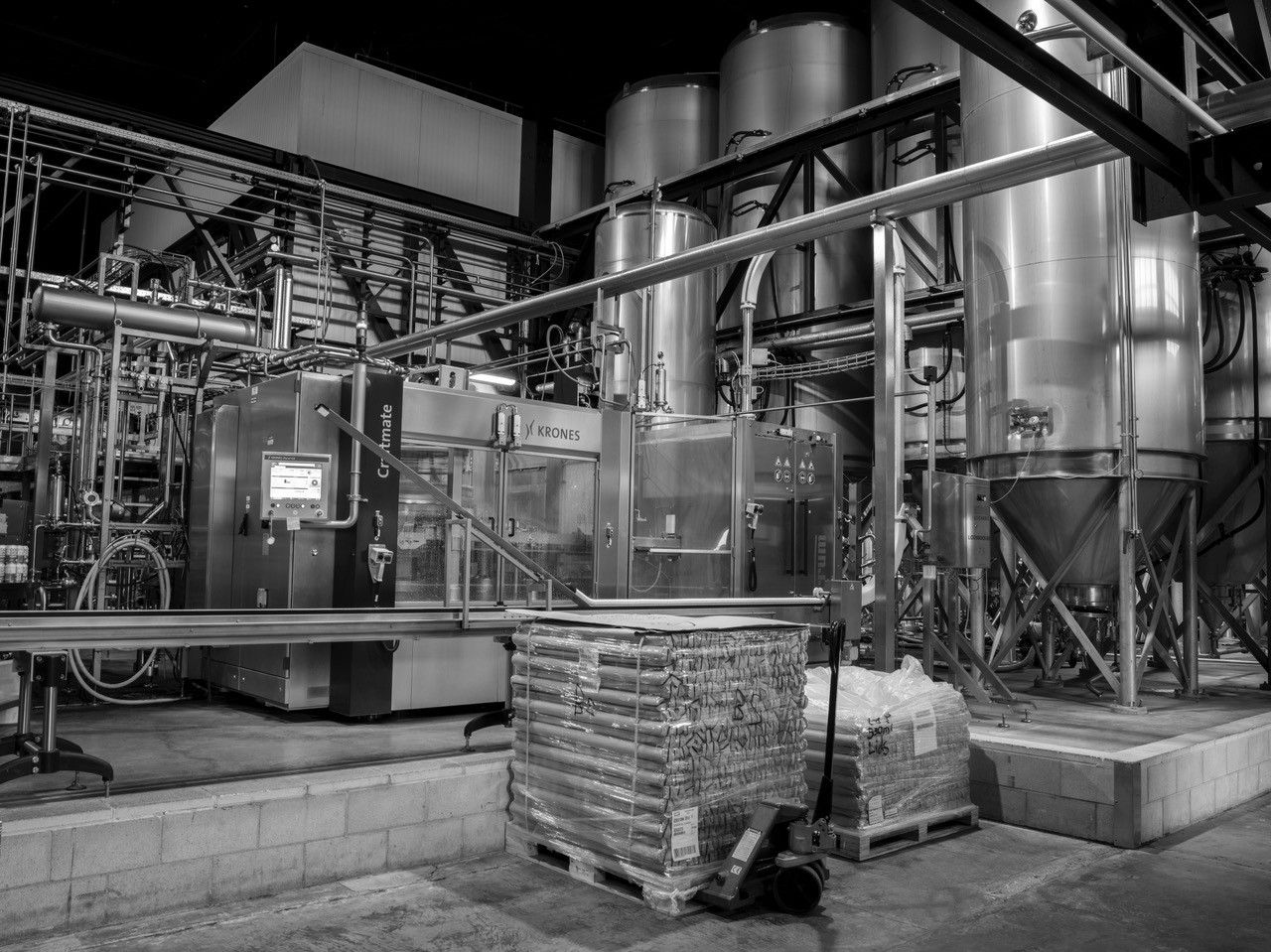 Industrial brewing equipment and tanks in black and white.